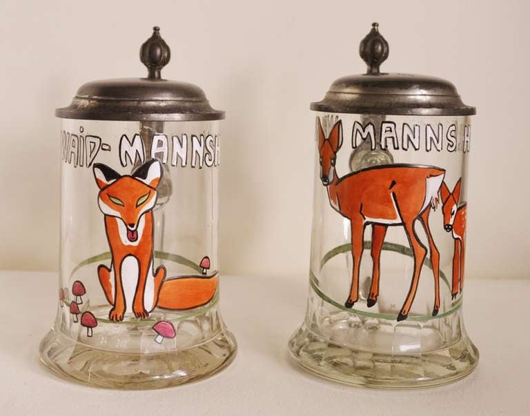 This rare pare of Theresienthal crystal hunting steins feature pewter lids signed in a lozenge by the Ed Gau.Company. Each is decorated with polychrome enamelled design, one of a deer plus her fawn and the other with a fox and both are in the style