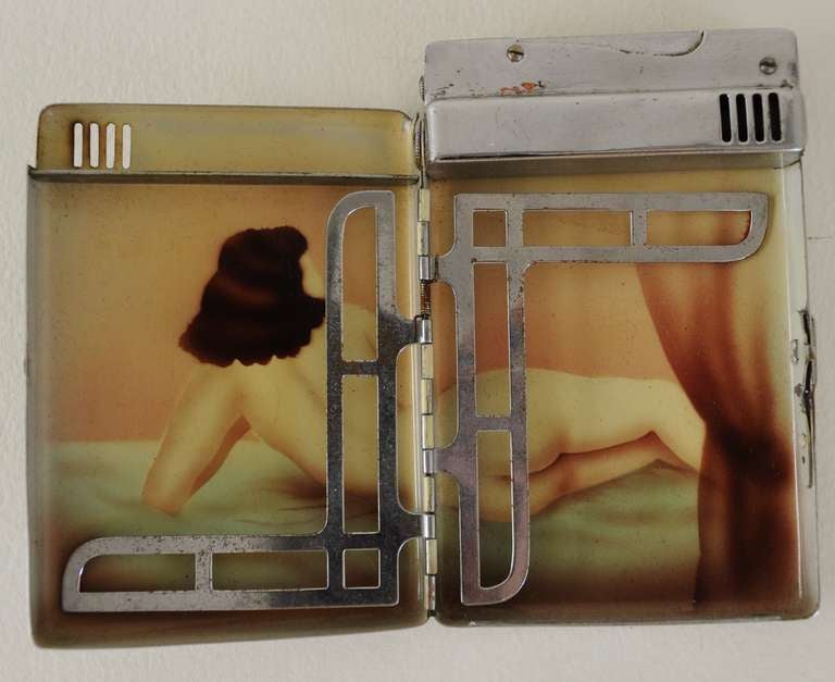This rare Japanese Magic Isazer erotic chrome-plated gentleman's wheel and flint lighter/ cigarette case combination features linear geometric Art Deco designs to the front and back of the case and an unused monogram plaque. On opening the interior