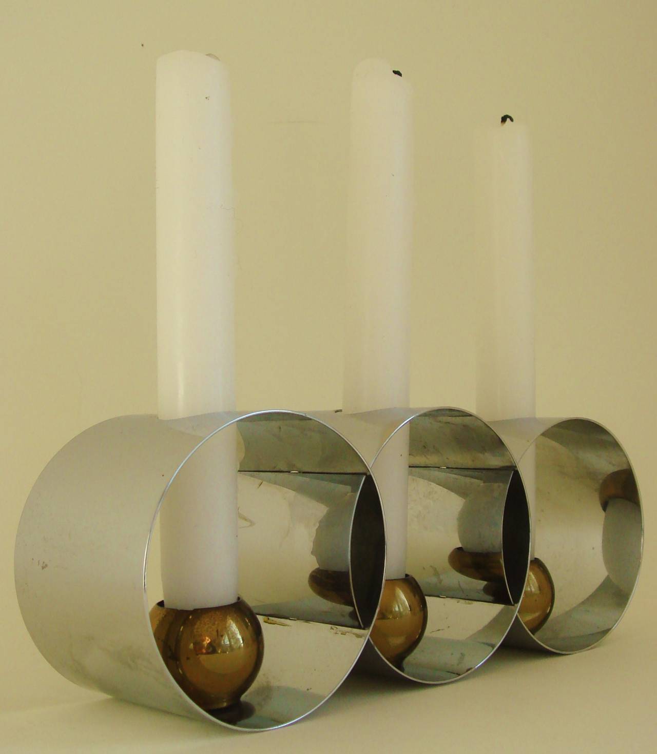 These beautifully executed American Art Deco pair of triple chrome and brass candle holders are known as 'Candlespheres'. They were one of the only two pieces created for Revere by the very accomplished and multi-disciplined designer Helen Dryden,
