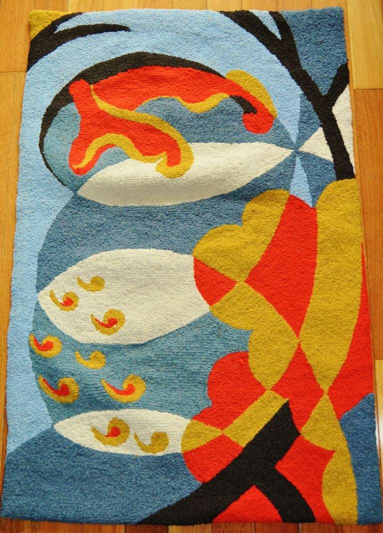 This American Art Deco hooked wool and rag rug is a vibrantly colored abstract representation of fish and underwater plants in an aquarium. Both the drawing and the choice of colors are masterful.