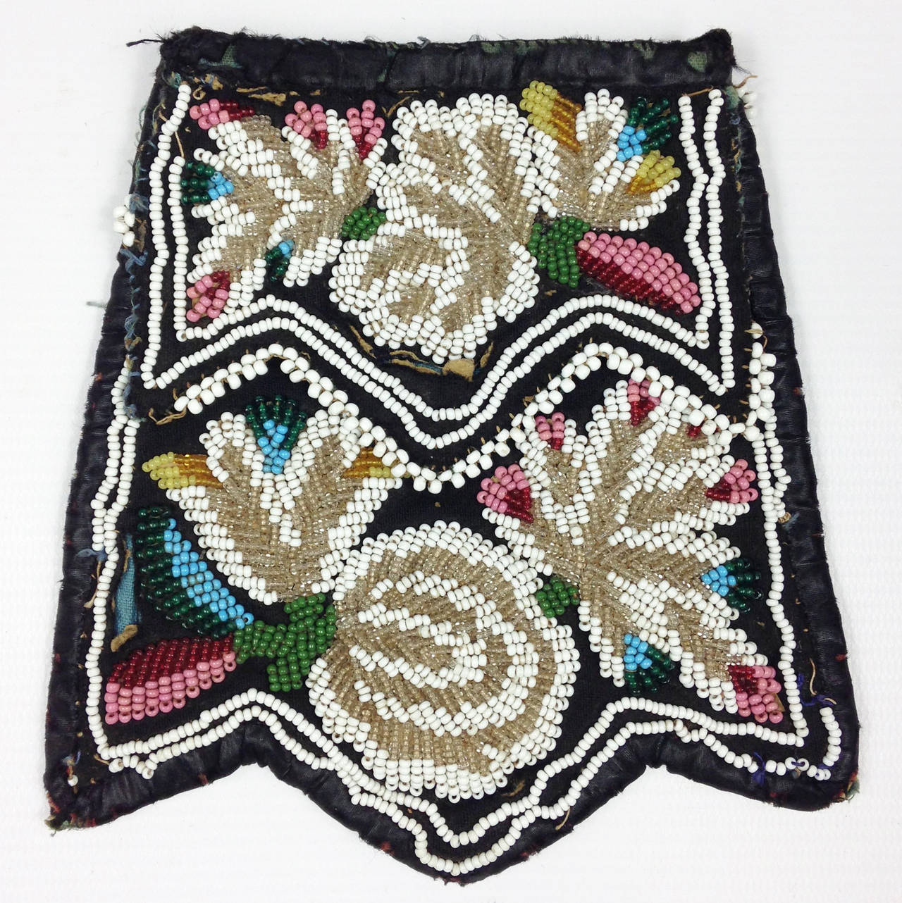 A rare example of an Eastern Woodlands beaded purse in the Niagara style.

Double-sided cloth bag with black silk edging. Paper patterns have been placed on the panels which in turn have been decorated elaborately with several colors of opaque and