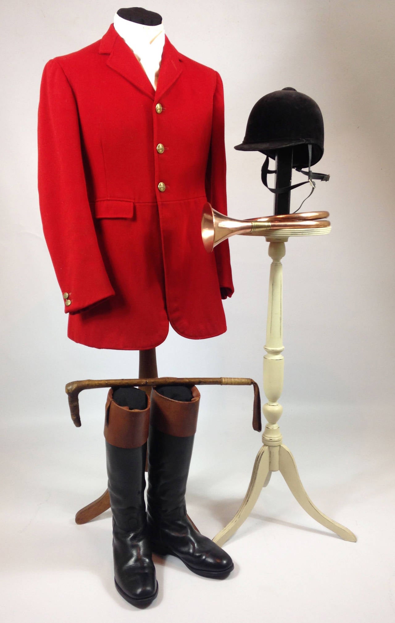 A very rare and decorative mid-20th century English hunt ensemble.

The group consists of a hunting 'pink' coat of heavy wool and cloth by Hogg, Sons & J.B. Johnstone Ltd of London with a full set of buttons to the Vale of White Horse,