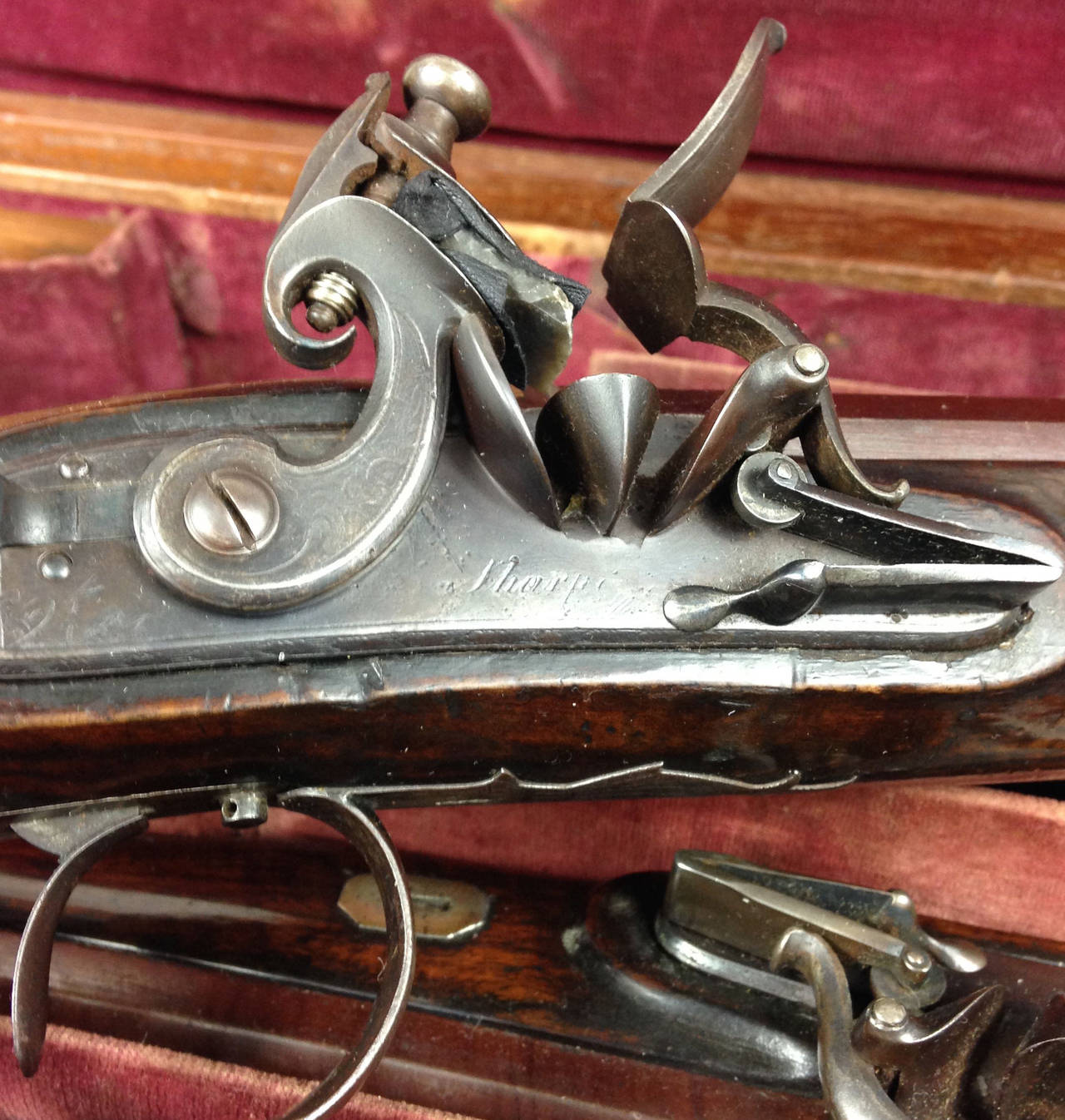 A fine pair of cased flintlock officer's pistols by Sharpe.

With finely chequered butts and 9