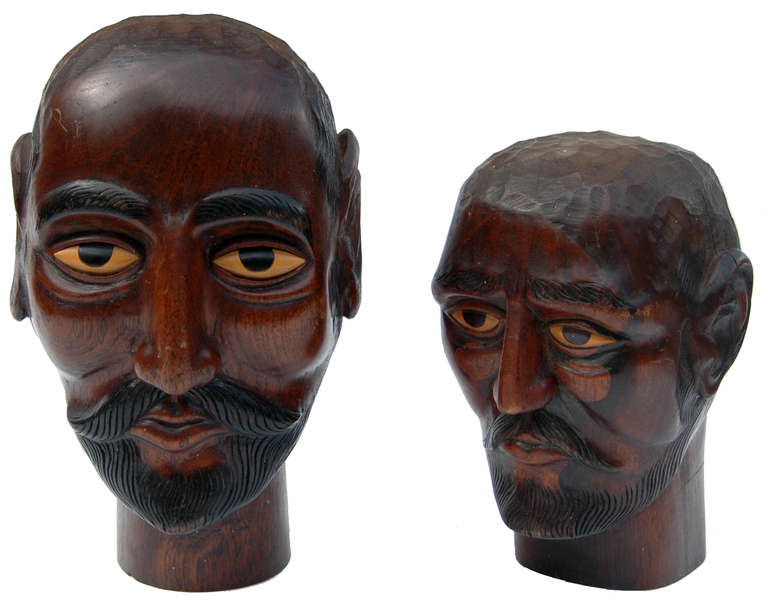 A lovely pair of mid-20th century carved teak Gentleman with ebonized features.The size stated below is for the larger heard pictured on the left. The smaller measures approximately 28cm (11