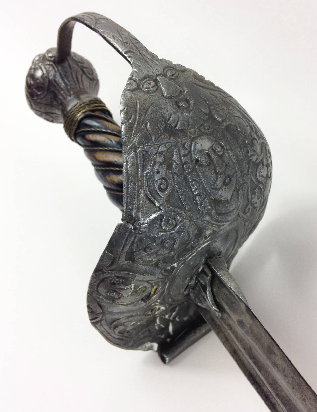 A good example of an English Civil War era 'Mortuary' hilted backsword.

An iron hilt of typical form for a sword of this pattern. Decorated with foliage and various masks, including 3 depictions of Charles I. Globular pommel and what appears to