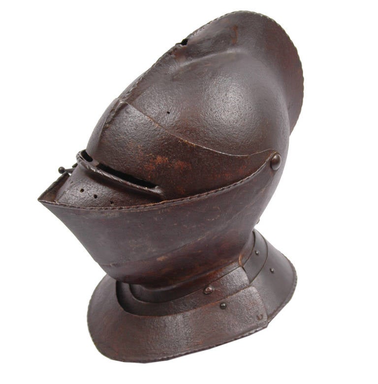 A very fine and rare English close helmet, more than likely made for a funerary achievement.

Of steel construction showing signs of original paint. A single piece skull with a raised cabled centre comb pierced for attaching a decorative plume or