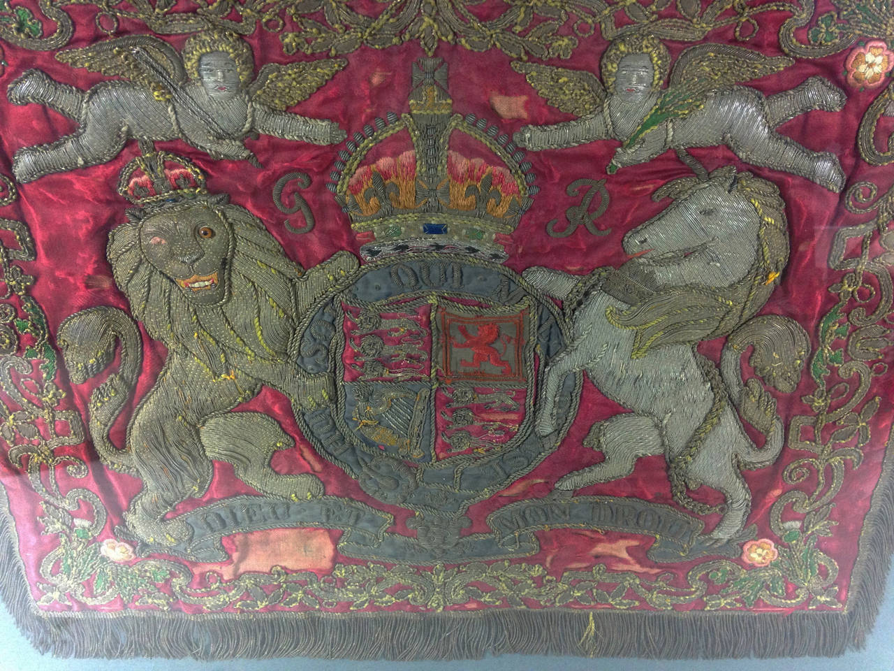 An extremely rare George V era Household Cavalry trumpet banner (1910-1936). 

A crimson damask silk ground, embroidered with the Royal Coat of Arms of George V in gold and silver bullion wire. Edged along 3 sides with a gold thread fringe.