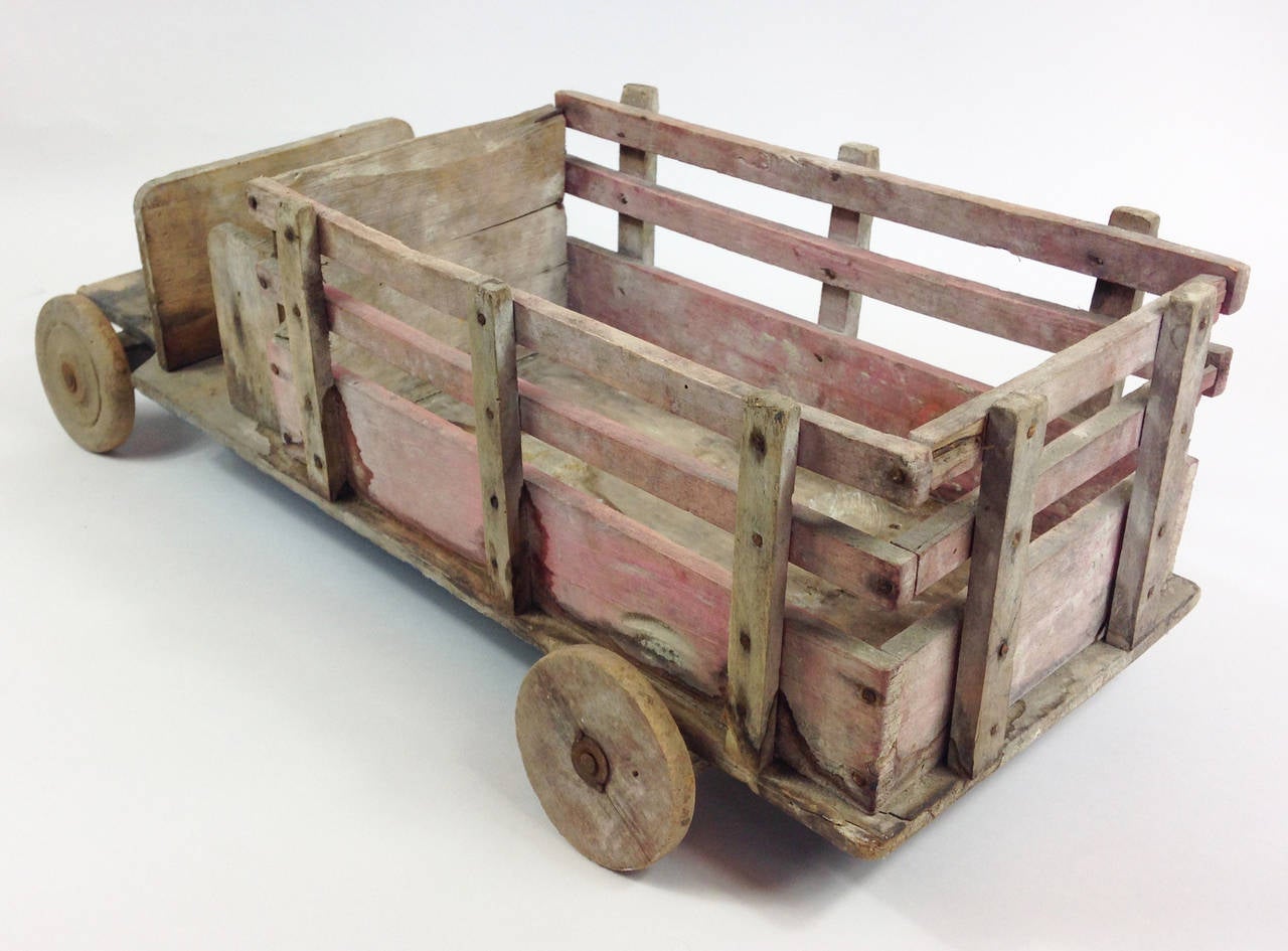 A naive scratch built toy wooden truck. Originating from France, this piece has been crudely assembled and stained which adds to the charm.

Would be prefect for displaying items or plants in the loading area.
