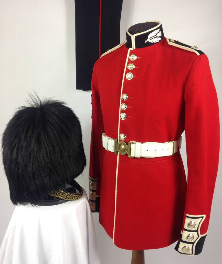 A very rare and extremely fine example of a British Army Scots Guards sergeant's uniform. Consisting of genuine issue Bearskin cap which in itself is in wonderful condition, Scarlet ceremonial tunic with a full complement of buttons, white leather