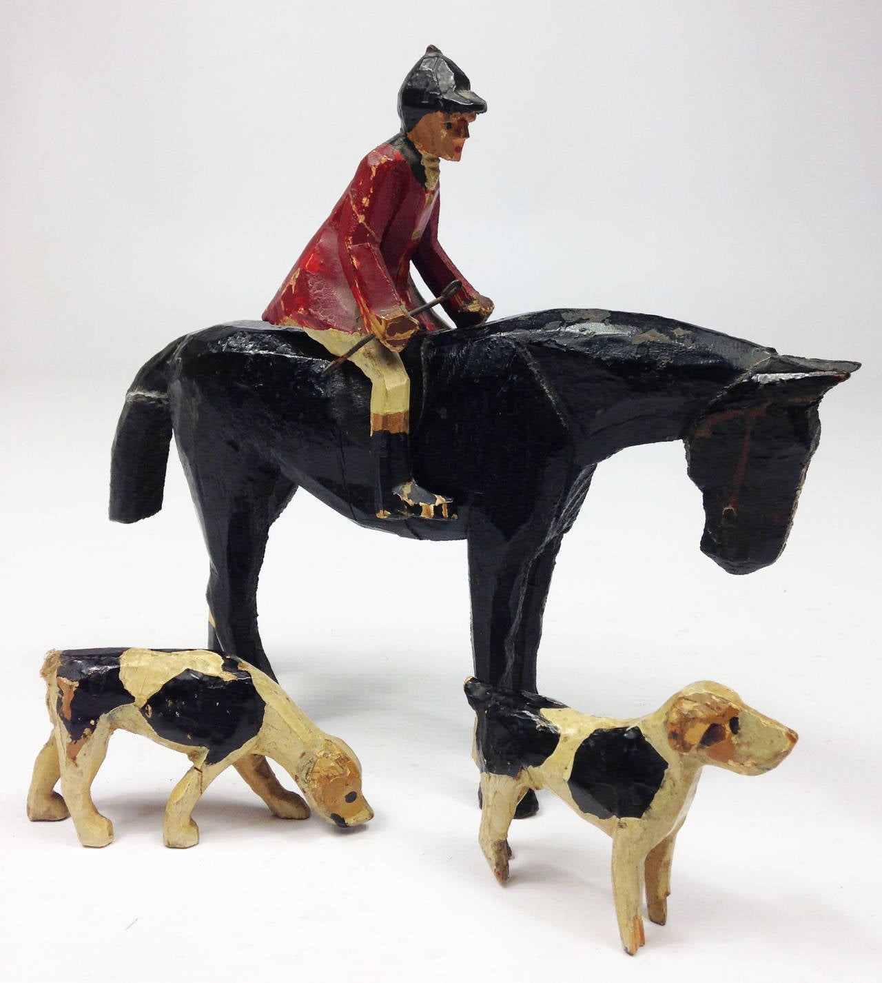 A lovely 19th century English Folk Art group depicting a mounted huntsman with 2 hounds.

Charming, naive hand carved and hand painted pine. An old break to the horse's tail but this doesn't detract. The size stated is for the huntsman whilst on