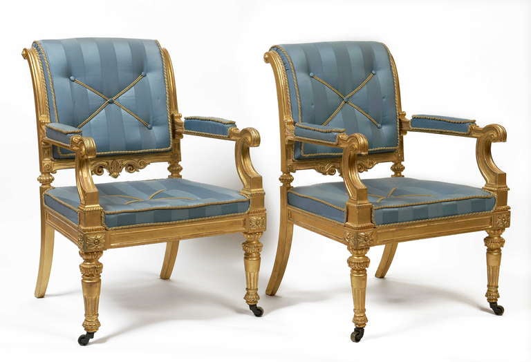 A fine Pair of carved giltwood Armchairs in the manner of Messrs Morel & Hughes, upholstered in blue striped silk and gold soutache.