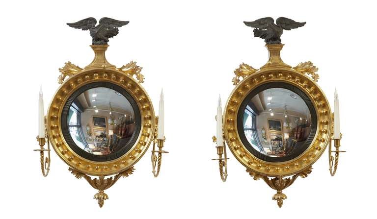 A fine and small pair of Regency convex mirrors, English, circa 1810 electrified.