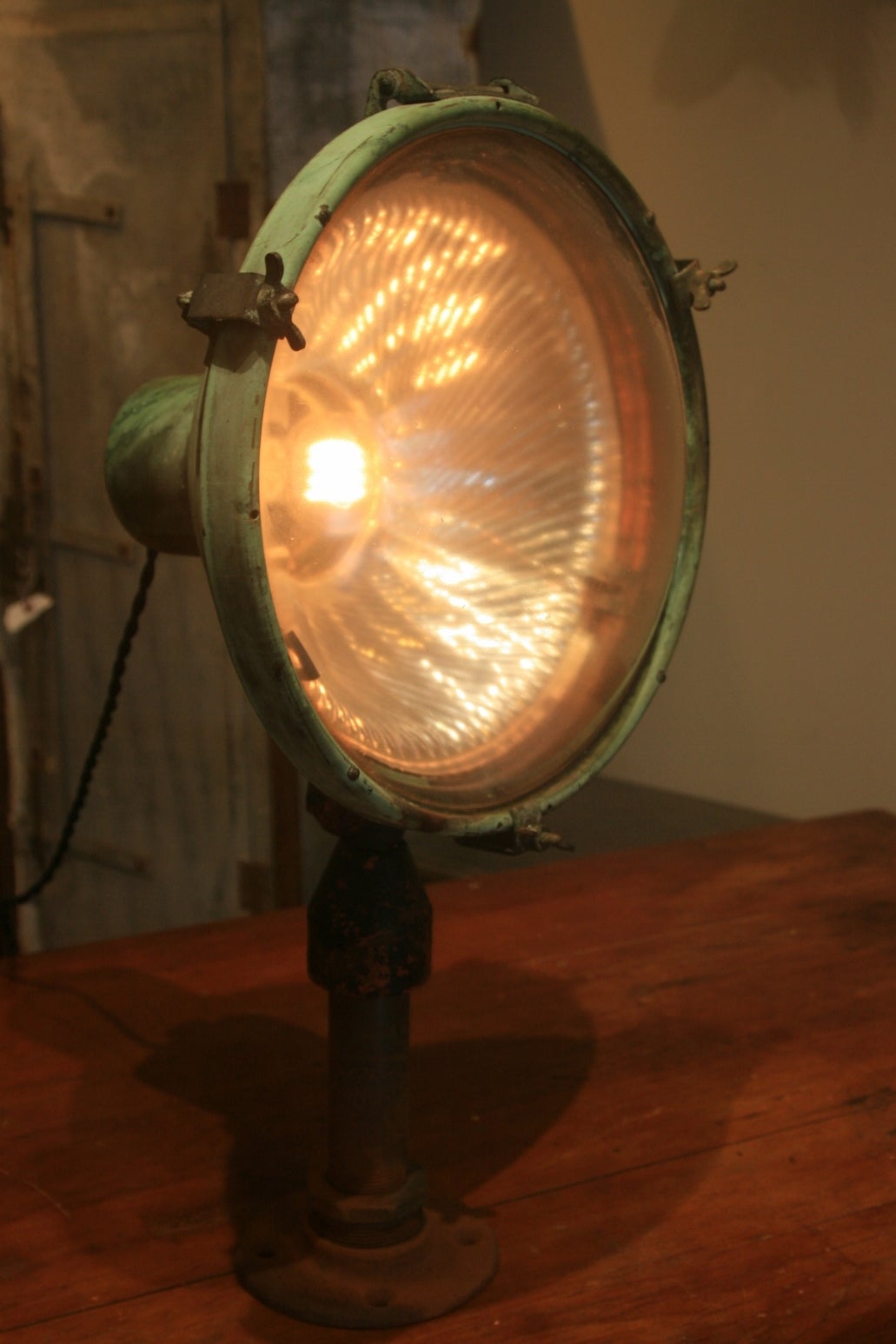 This lamp is such a beautiful object you don't need to use it as a light.  The exterior has a beautiful verdigris and and bubble lens. Inside is a mercury shade.  Made for outdoor use , it was probably a floodlight.It has a lower wattage bulb more