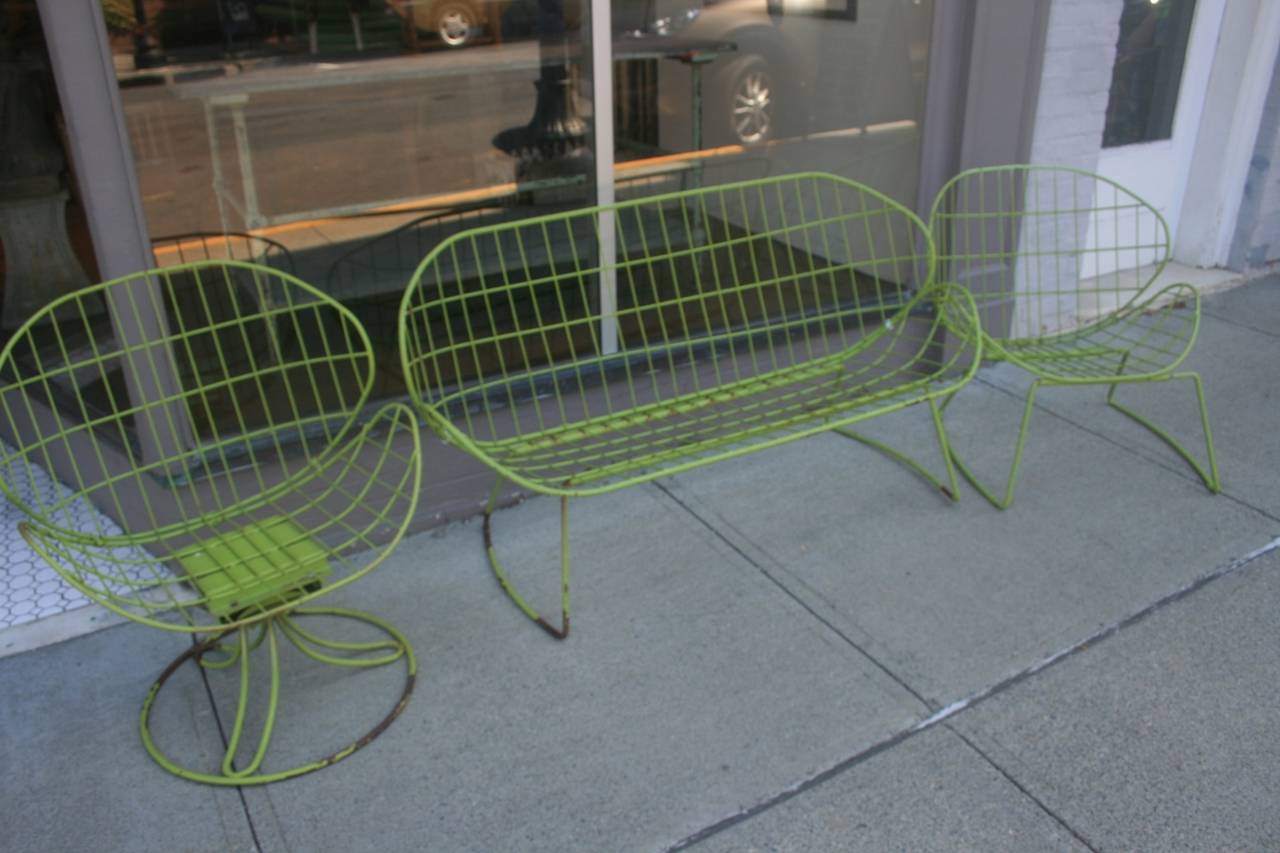 This beautiful set of Mid-Century garden chairs include one settee one swivel chair, and one chair. The color is fantastic! All have original cushions and original paint. Some have small rust spots on the bases.