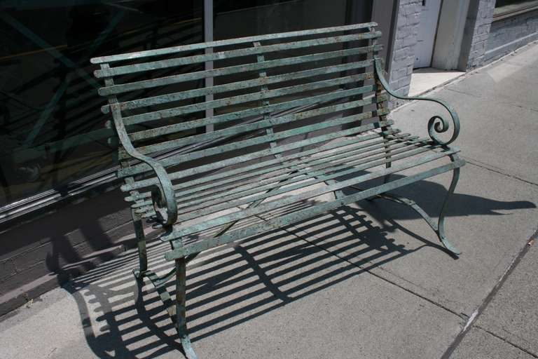 This is a beautiful heavy guage wrought iron park bench circa 1890.  It has a mint green paint with some areas of rust.  Looks it's age, but it's as sturdy as new.