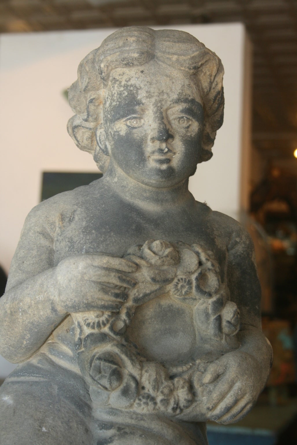 Beautiful 19th century carved limestone garden sculpture of a Putti. The figure is nicely carved and has an interesting patina reminiscent of the old soot stained stone homes in the city of London which is probably where this is from.