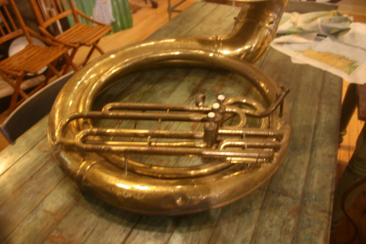 Giant 19th century Sousaphone. A great piece of sculpture and it works. The brass is a little worn. Mother of pearl finger buttons. Made in Elkhorn, Wi. , U.S.A. It is missing the mouthpiece and has a few dents around the outer tube.