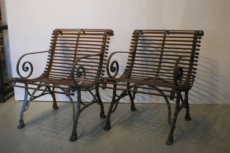 Beautiful pair of 19th Century French Cast Iron garden chairs. They retain the original copper maker's label on the top front of the chiars: S Sauveur/ Arras.