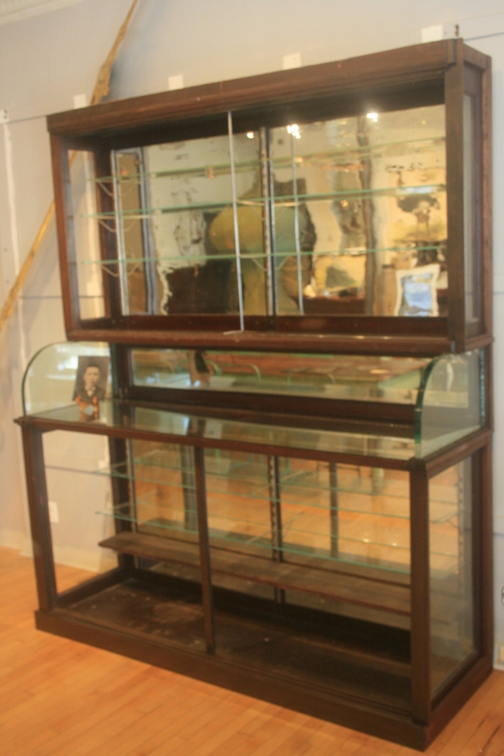 Beautiful apothecary mirror backed cabinet or showcase, circa 1890. It came from a pharmacy on 7th street in Downtown Philadelphia. The mirror is mercury glass and such a large area of it is very striking. It looks like water. There are two very