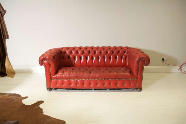 This is a very very good pair of vintage leather chesterfield sofas in pillar box red.  They are to undergo some remedial work by ourselves to ensure excellent order.

They have fully coil sprung seats and have been correctly crafted around an