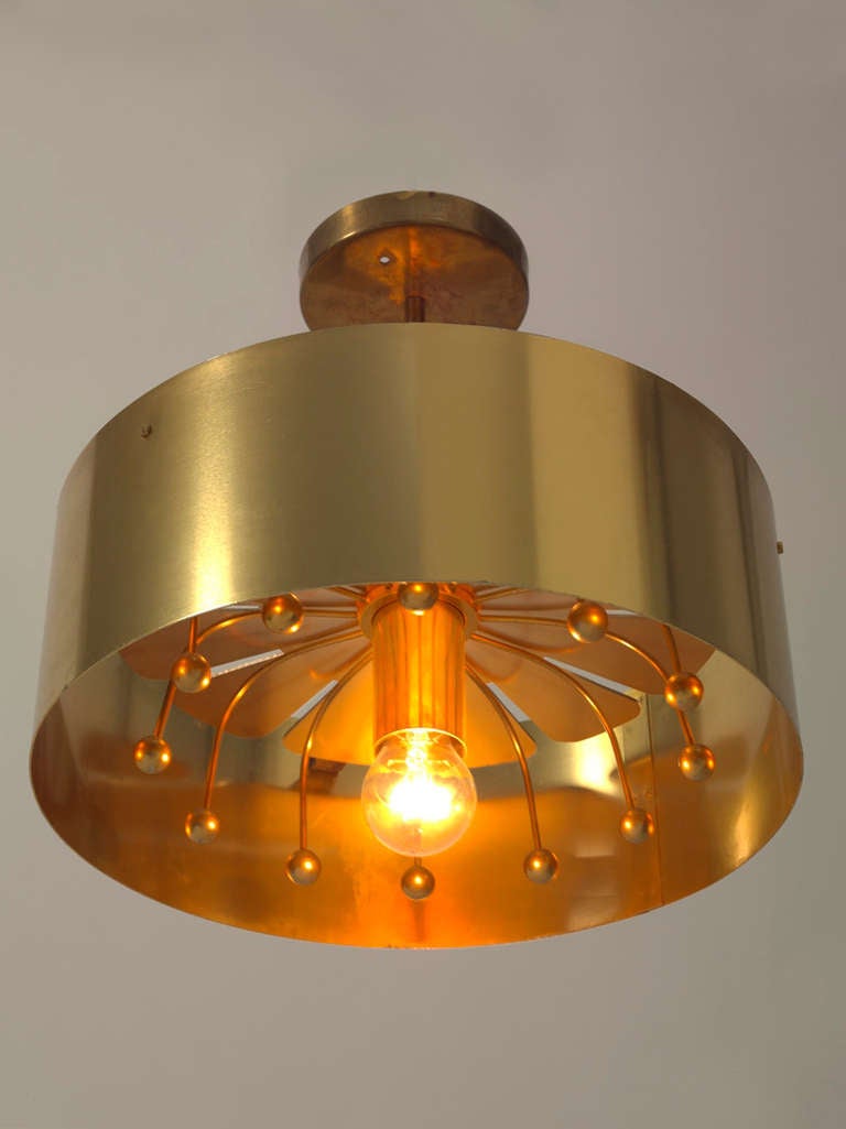 Geometric brass metal ceiling lamp with clean lines, in the style of by Pierre Cardin. The design is inspired by flowers, typical 1960's theme, where the petals are graphically shaped in brass and brass balls to represent the pollen. 
Excellent lamp