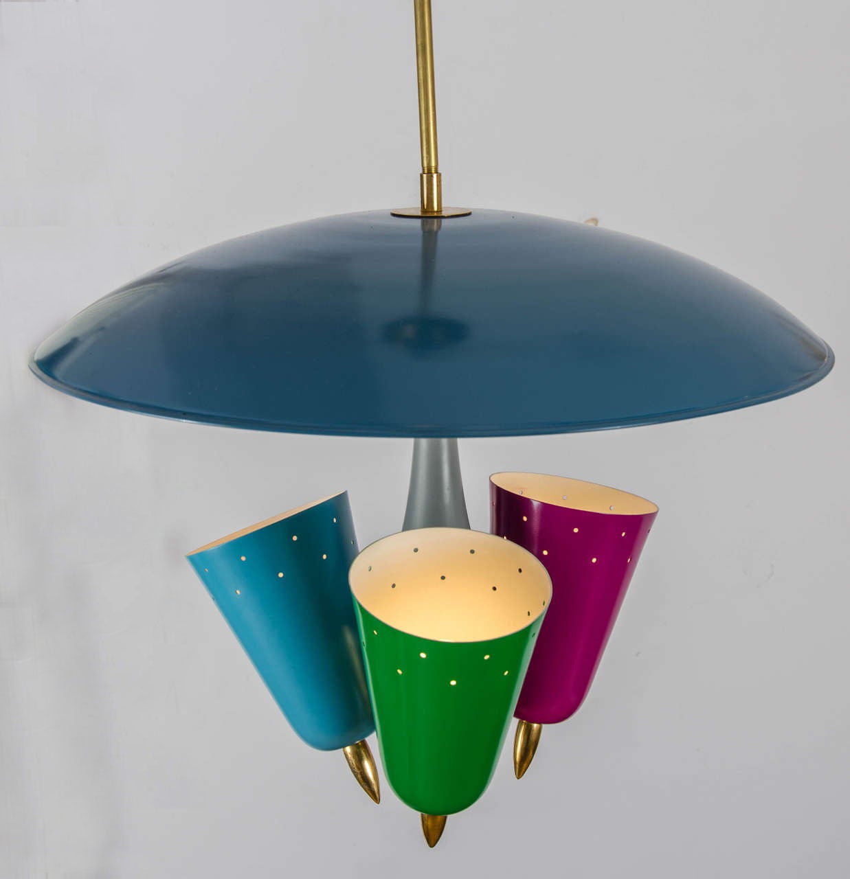 Mid Century Modern five colored metal pendant has three round cone shaped light sources in spun aluminium attach to brass fittings leading to a central umbrella shaped light diffuser hanging over the lights.