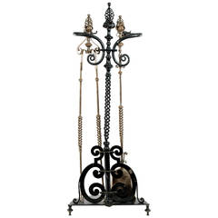 A French Wrought Iron Fireplace Tool Set with Sculpted Dolphins