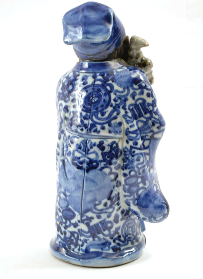 A blue and white Qing Dynasty statuette of the Old Man of the South Pole, known in Japan as Jurōjin, one of the Seven Gods of Fortune and the personification of the Southern Polar Star. He is depicted with a staff and holding a scroll, on which is