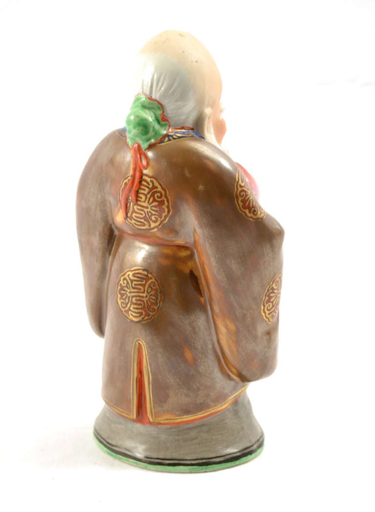 A polychromed and gilt porcelain statue of the Chinese God of Longevity holding a sacred peach. 

The peach is an emblem of happy marriage, spring, and long life. In legend there was a peach tree that blossomed once every 3,000 years and bore the