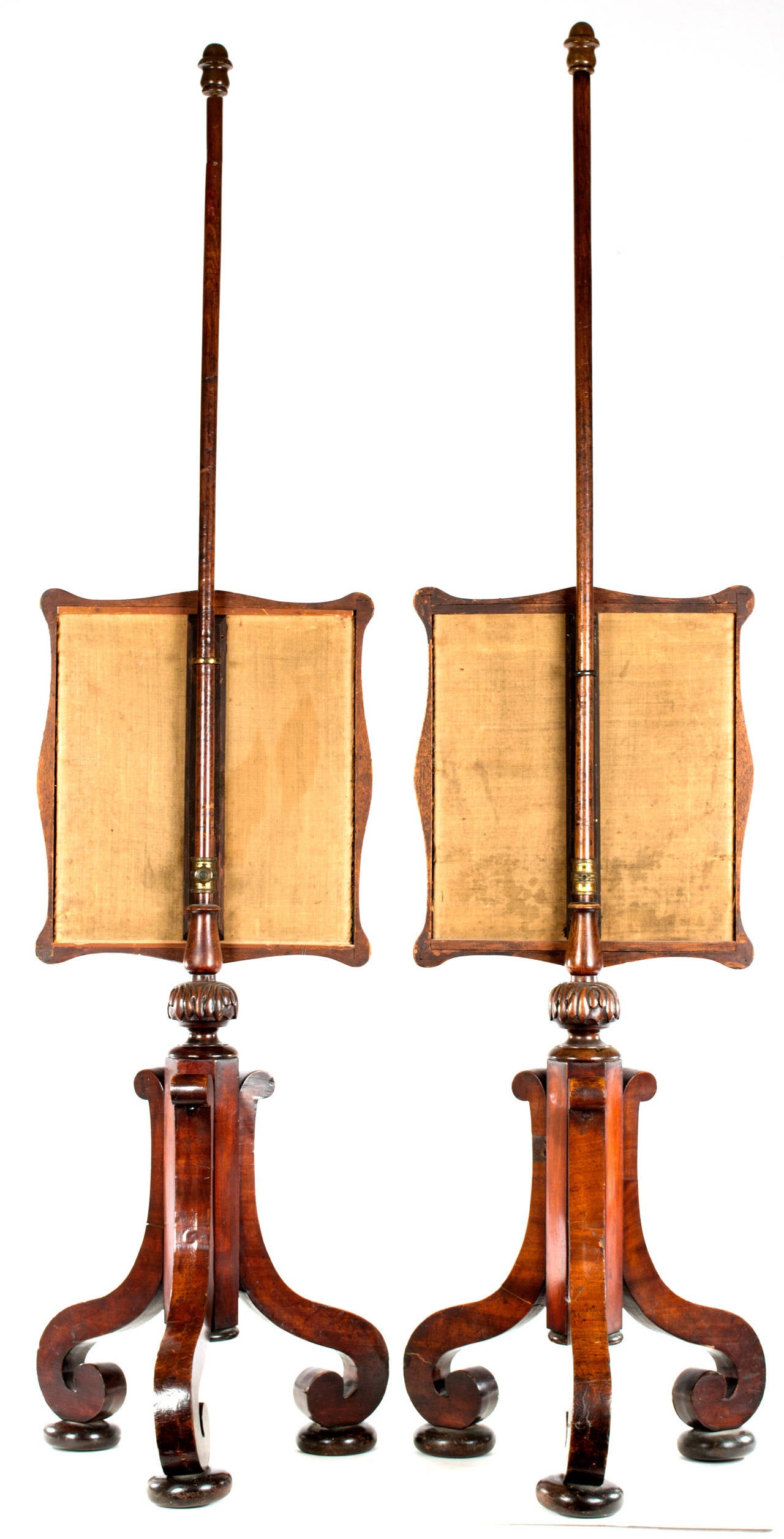 Two very fine English fire or hearth screens dating from the third quarter of the nineteenth century. Each embroidered silk screen is encased in and attached to a three-footed Stand of figured mahogany. The screens shield from the heat of the fire