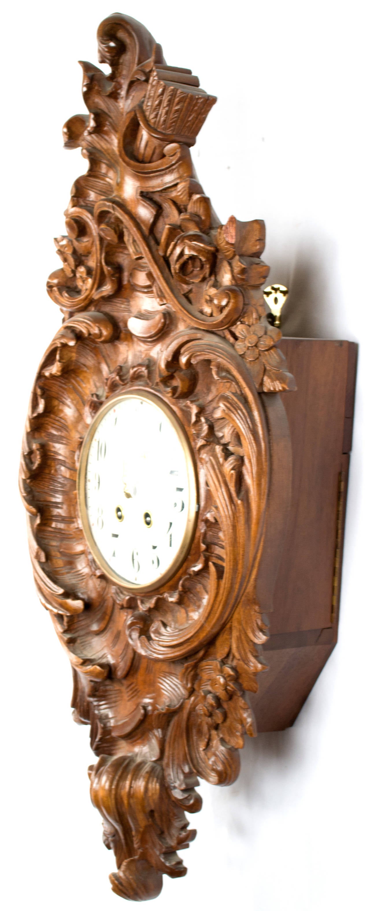A finely carved Rocaille (i.e. Rococo) style walnut clock with asymmetrical acanthus leaves in C and S scrolls, topped with a roses, and arrows.