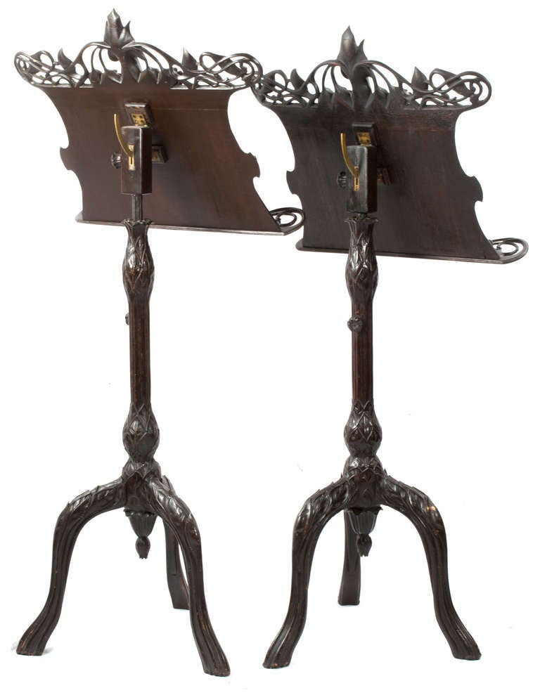 Fitted with brass adjustable hinges, these pierced and carved music stands are richly carved sinuous vines and flowers.