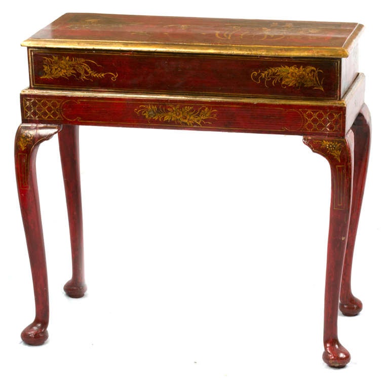 A two-drawer, French chinoiserie Louis-XV table from the last quarter of the eighteenth-century is lacquered in red and painted with Chinese country scenes in gold.