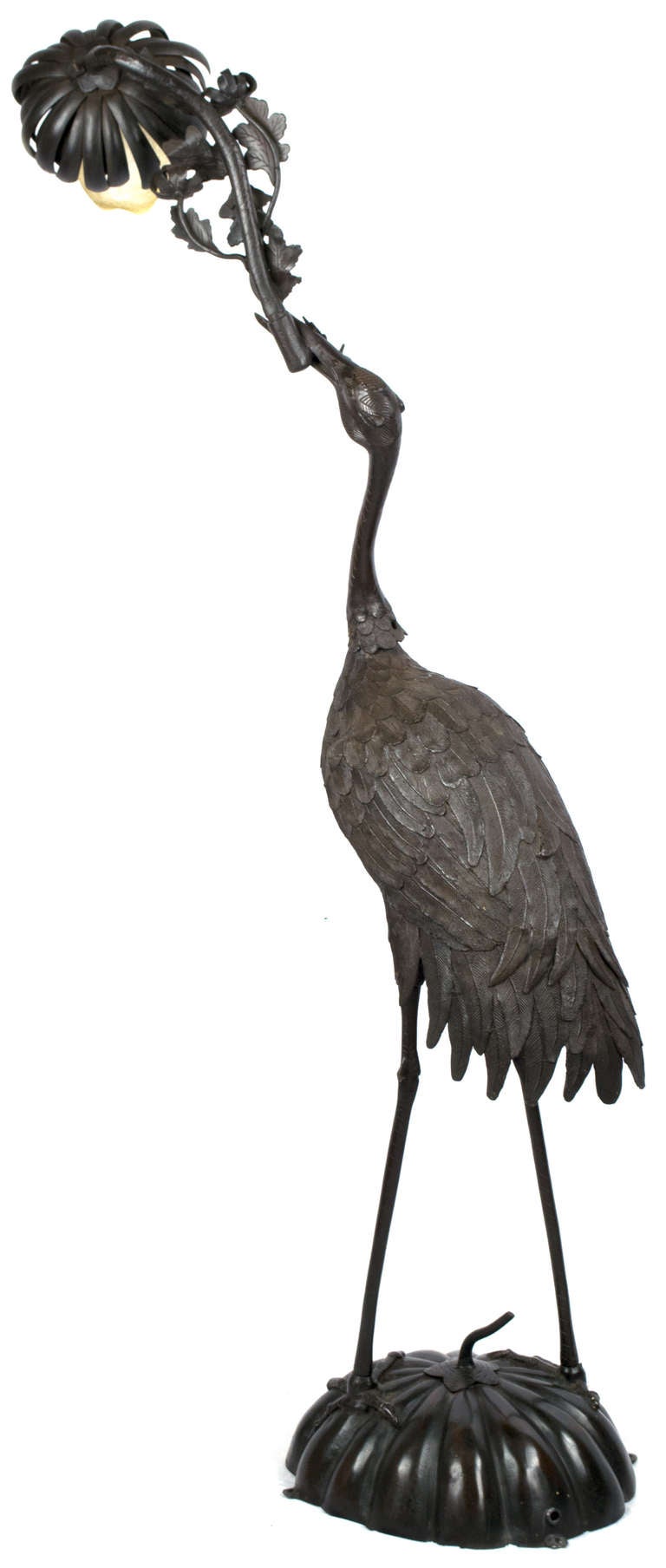 This sculpture of a crane standing on a gourd and holding aloft a blossoming branch adjusts in three places (i.e. the neck, branch, and top). It is exquisitely cast, cold chased, and fitted with a period, blown-glass shade.