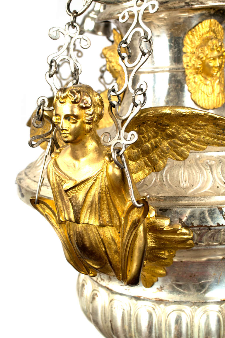 Known as a thurible to Catholics, this large censer — used to waft incense —  has been wired with a light and is suspended from decorative linked chains connected to three gilt angels. The neck is decorated with gilt seraphim.