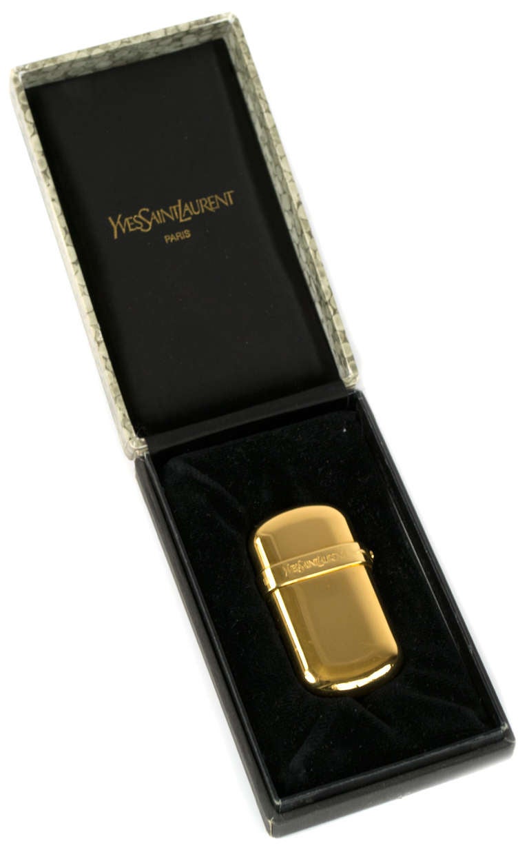 In fine working condition, this 1960s Yves Saint Laurent (Paris) lighter is plated in gold and comes in its original box. The lighter is stamped with the number 001426.