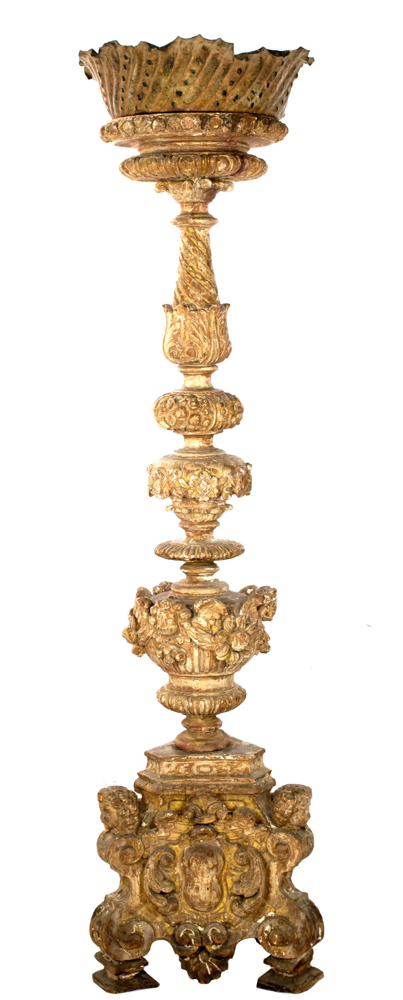 Carved with elaborate depictions of putti, floral sprays, and architectural classical elements, this nineteenth-century candelabra is topped with a bronze bobeche and stands at over six feet.