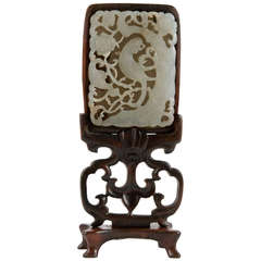 A Qing dynasty carved jade plaque with stand