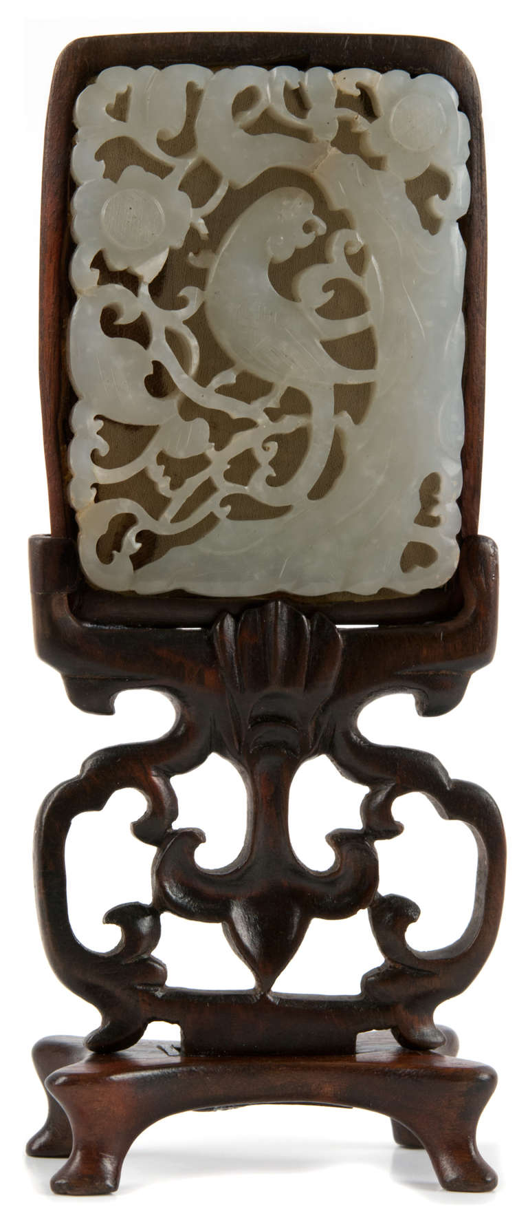 A light hued, intricately carved and incised jade plaque depicting an exotic bird and flowers.