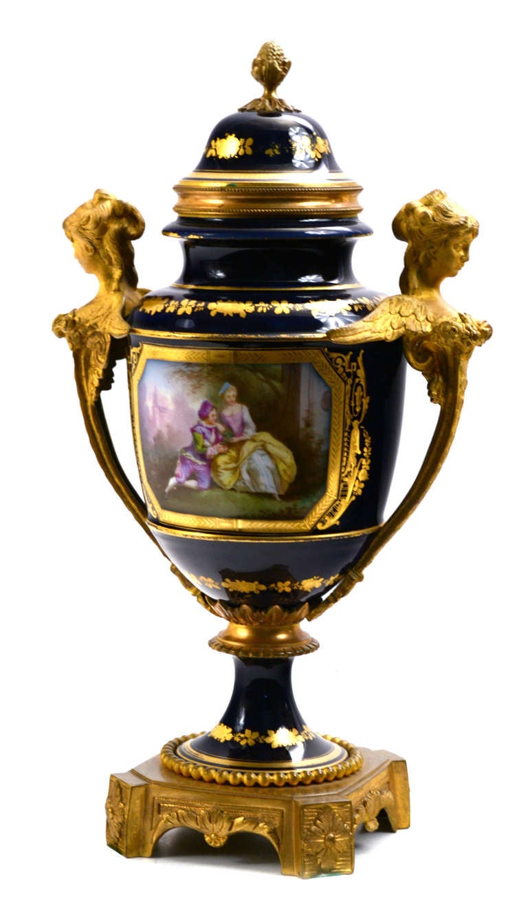 A monumental porcelain Sèvres trophy with scenes of romantic love and country life. The base, cover, and handles of winged caryatids are are gilt bronze.