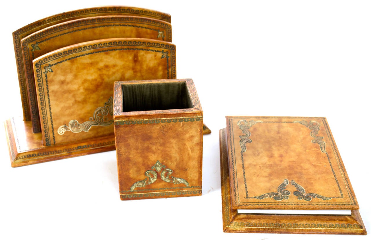 A gilded and marbled calfskin desk set — including tray, desk pad, letter holder, pen holder, and notepad holder — with silk interior, made in Venice.