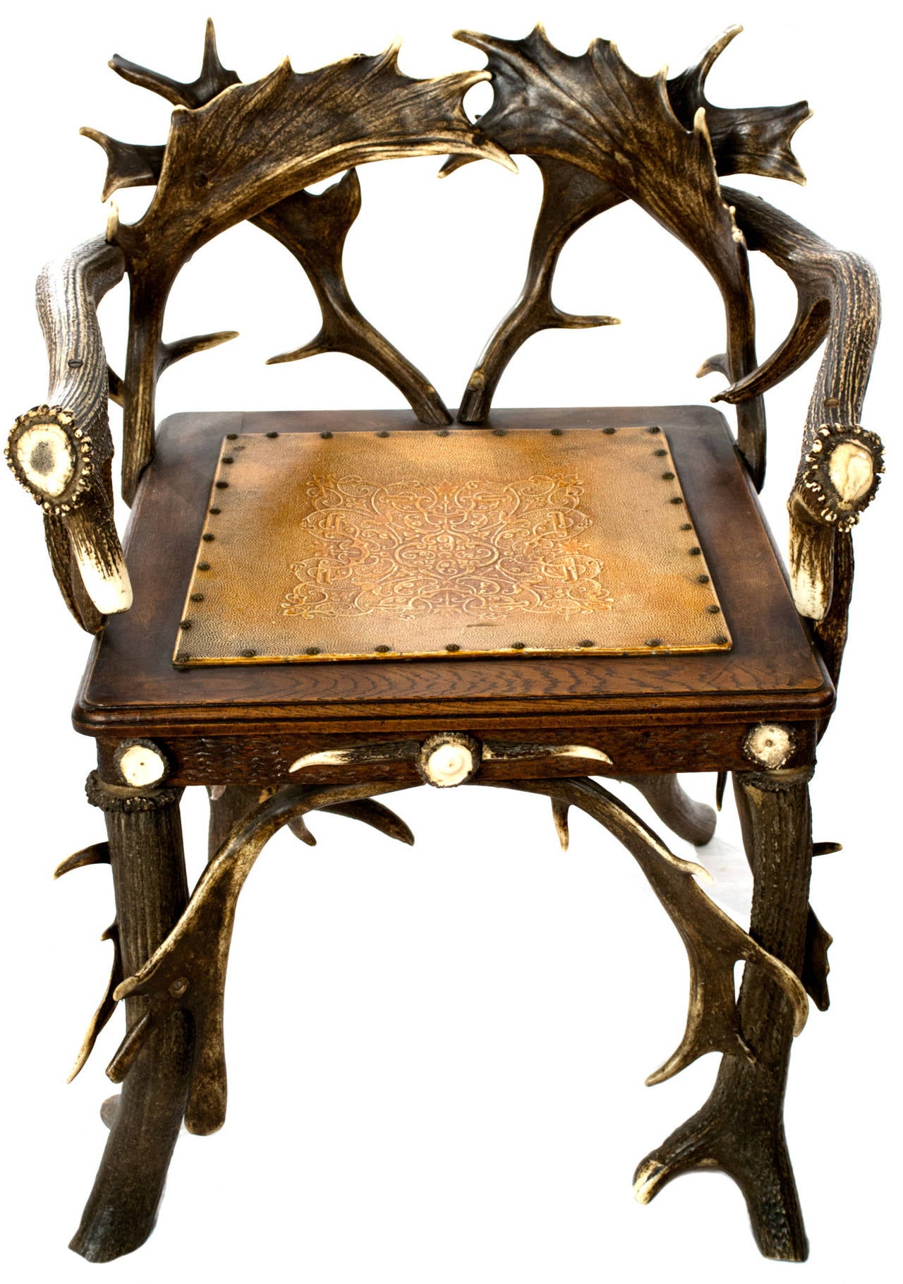 Two nineteenth-century Black-Forest arm chairs with the arms, back, and legs made from fallow and red deer antlers, the seat from hand-tooled leather and walnut.