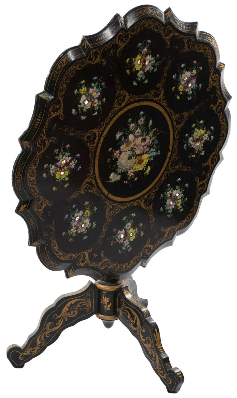 An ebonized French occasional table, exquisitely painted with bouquets of flowers and gilt.
