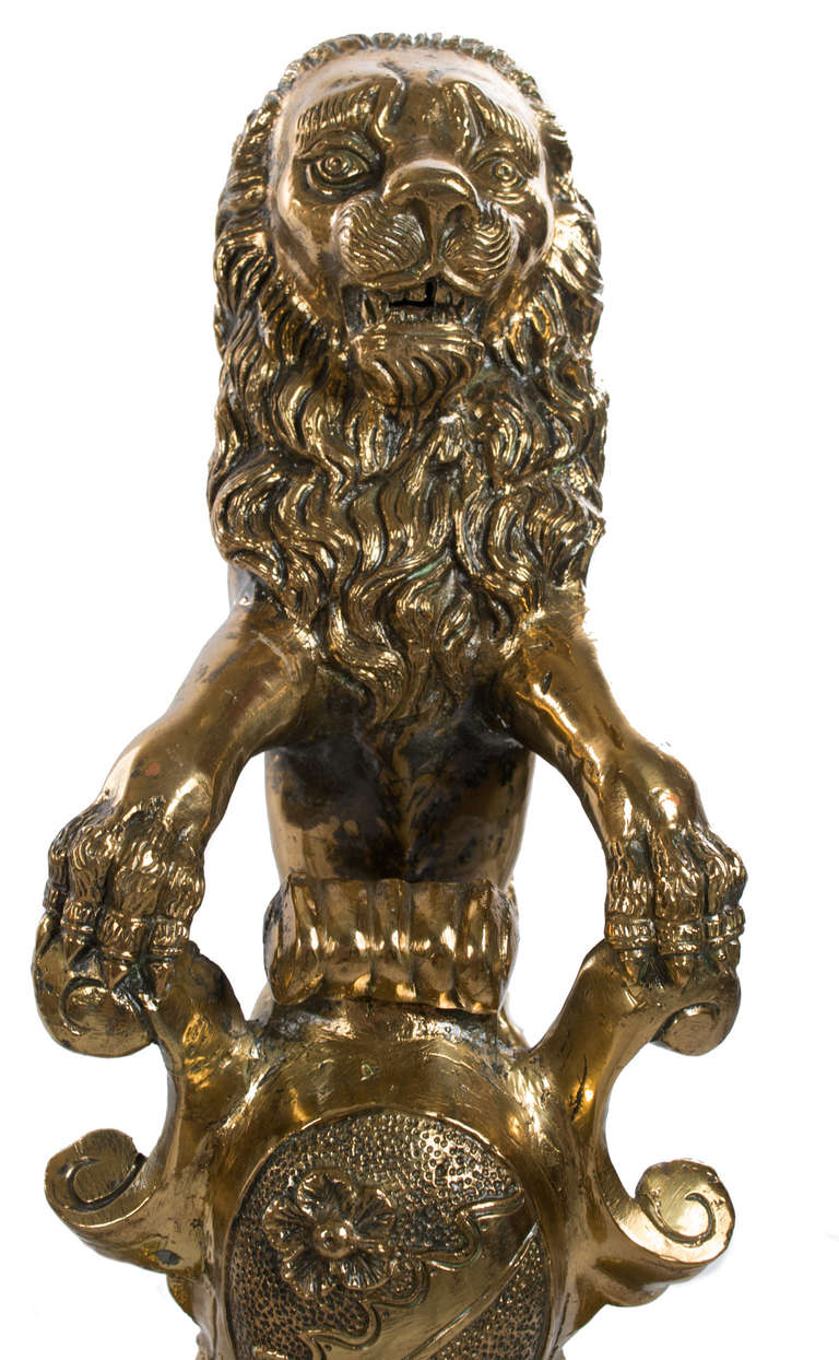 Featuring a dizzying and fanciful group of sculptures, which includes feet made of dragons with upturned heads, a central column of masks, putti, grape clusters, lion-paw feet and each andiron topped with a large lion, this set was made in England