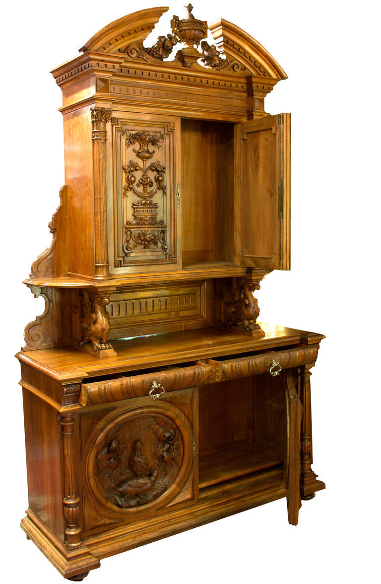 An exceptionally made, nineteenth-century St. Hubert cabinet, with the base featuring two large circular medallions with full-relief sculptural groups of carved starlings on the left and quail on the right. The center of the cabinet has two griffins