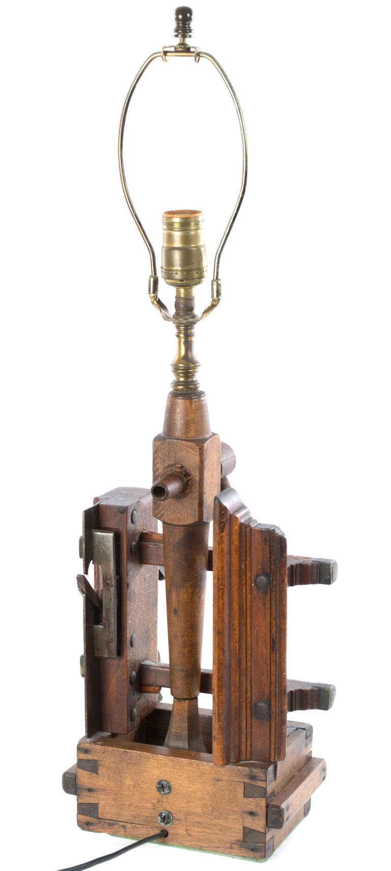 This unusual and charming table lamp is made from various, 19th century walnut tools (i.e. a lathe, box, spigot, and clamp) and is fitted with a brass harp.