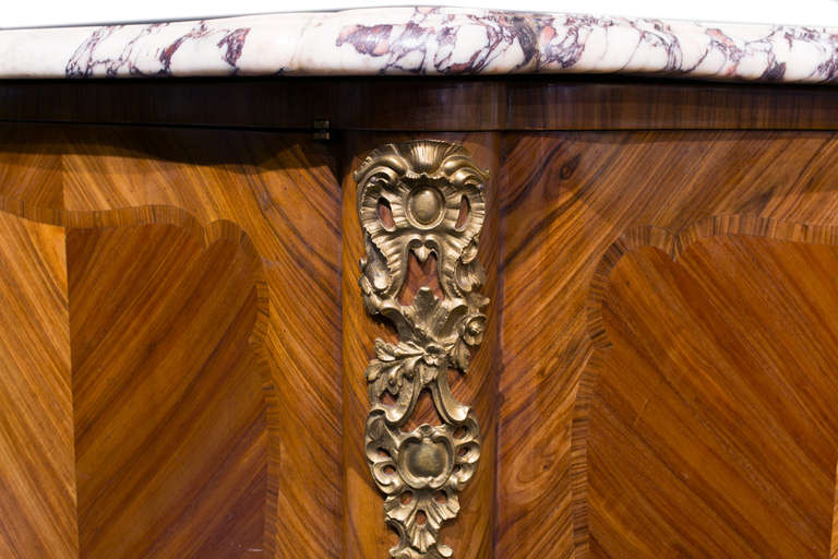 A large, marble-topped Louis-XV-style buffet with pierced ormolu appliqués, a body covered in figured mahogany parquetry, and the two central doors painted with beautiful gold and red lacquer flowers.