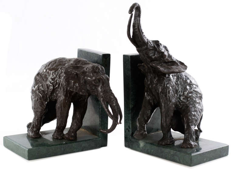 A pair of exceptionally sculpted cast bronze and dark patina African elephants mounted on green marble plinths.