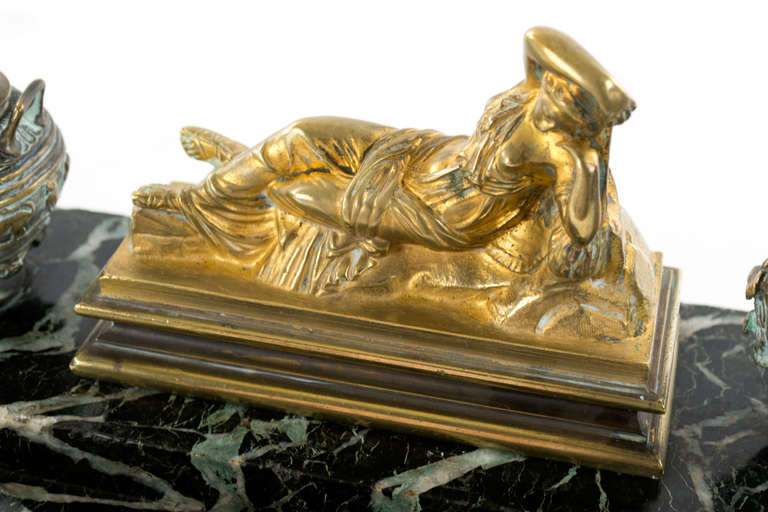 Topped with a sculpture of the Sleeping Ariadne, based on the 200 BCE sculptures found both in the Prado Museum (Madrid) and Vatican Museums (Rome), the sculpture lifts to reveal a large compartment for pens. On either side is a cast bronze urns