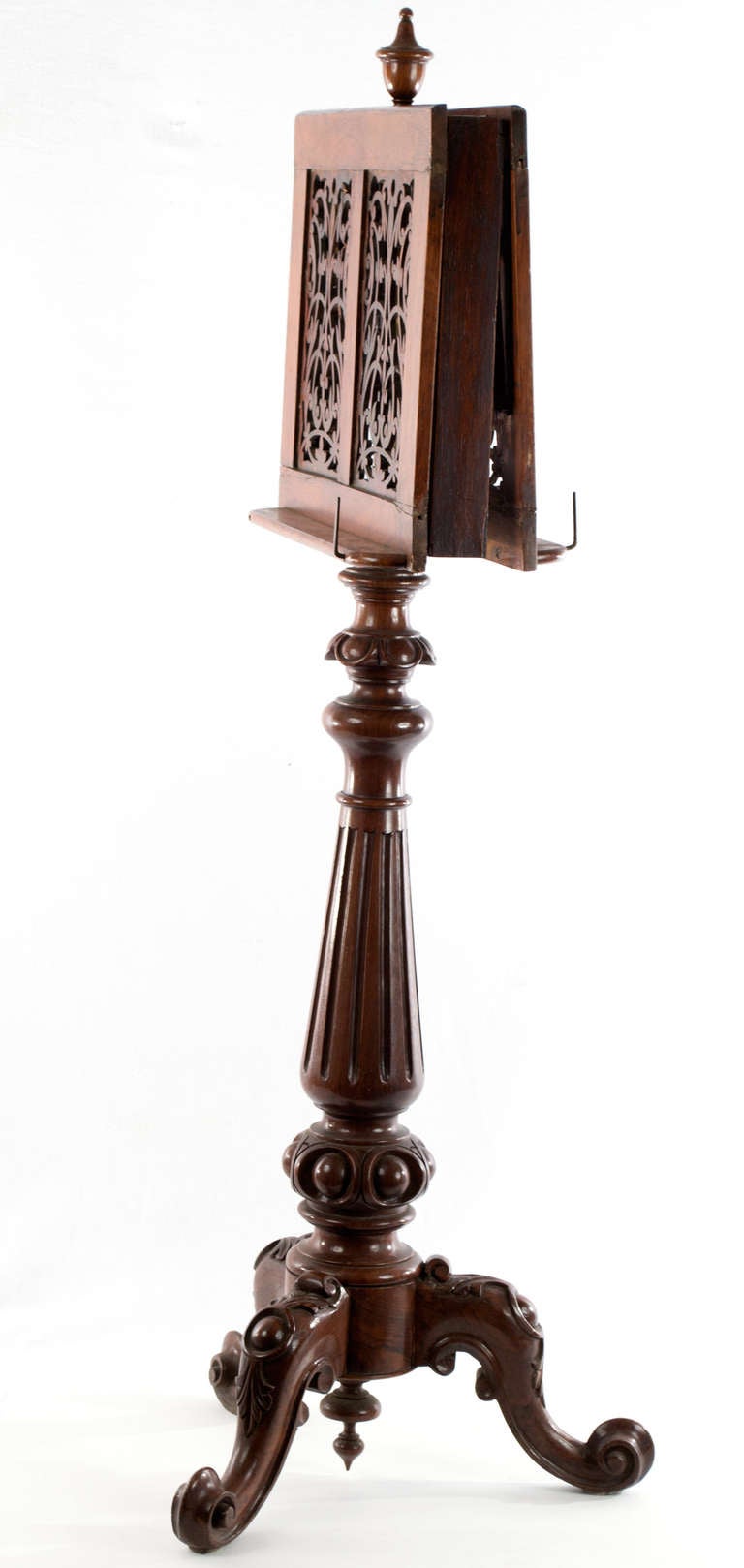 Carved from solid mahogany, this lectern or music stand folds inward for storage and can be adjusted in height — using hinges and inner workings made or solid brass. The faces of the stands are exquisitely pierced carvings of foliage sprays and